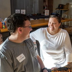 Two Campbell alumni talking and smiling at each other