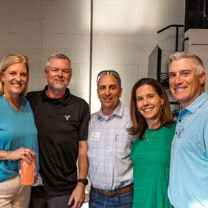 A group of five Campbell alumni posing for a photo